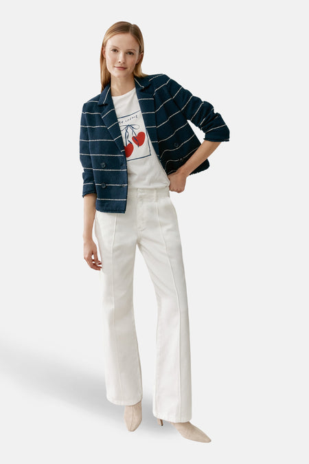 Blazer bleu rayé de MORE & MORE, porté avec un t-shirt imprimé et un pantalon blanc à jambes larges.
