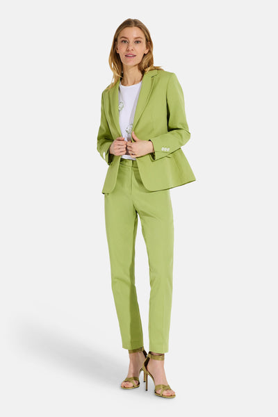 White short-sleeve t-shirt with floral embroidery, worn under green blazer and matching pants, full-length lifestyle view.