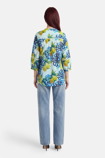 3/4-mouwen blouse in meerkleurig van MORE & MORE met citroen- en bloemenprint, gedragen met een klassieke blauwe jeans.