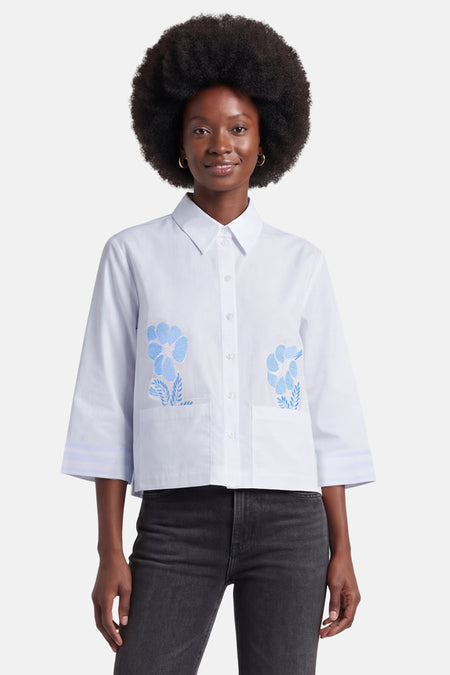 Chemise blanche de MORE & MORE à broderies florales bleues, manches 3/4 rayées et poches poitrine.