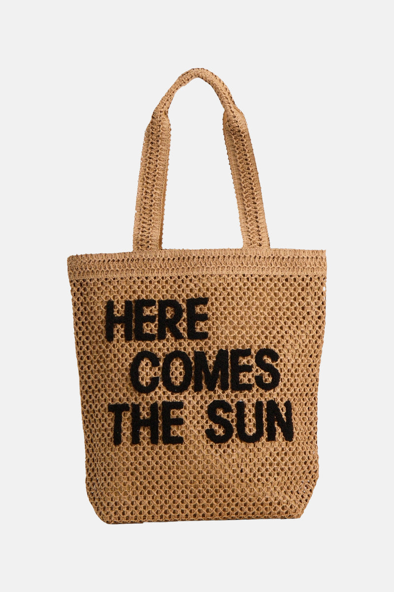 Sac à bandoulière beige de MORE & MORE en paille tressée avec le texte « HERE COMES THE SUN » en noir.
