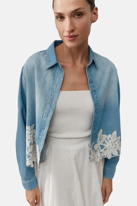 Lichtblauwe spijkerblouse van MORE & MORE met witte bloemenkant op de mouwen en zoom.