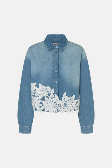 Lichtblauwe spijkerblouse van MORE & MORE met witte bloemenborduursels aan de onderkant en knoopsluiting aan de voorkant.