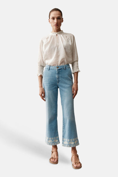 Jean droit en denim bleu clair de MORE & MORE, avec broderie florale en bas des jambes.