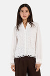 White long-sleeve blouse with lace detailing by MORE & MORE, featuring scalloped edges and button front, worn with brown ribbed pants.