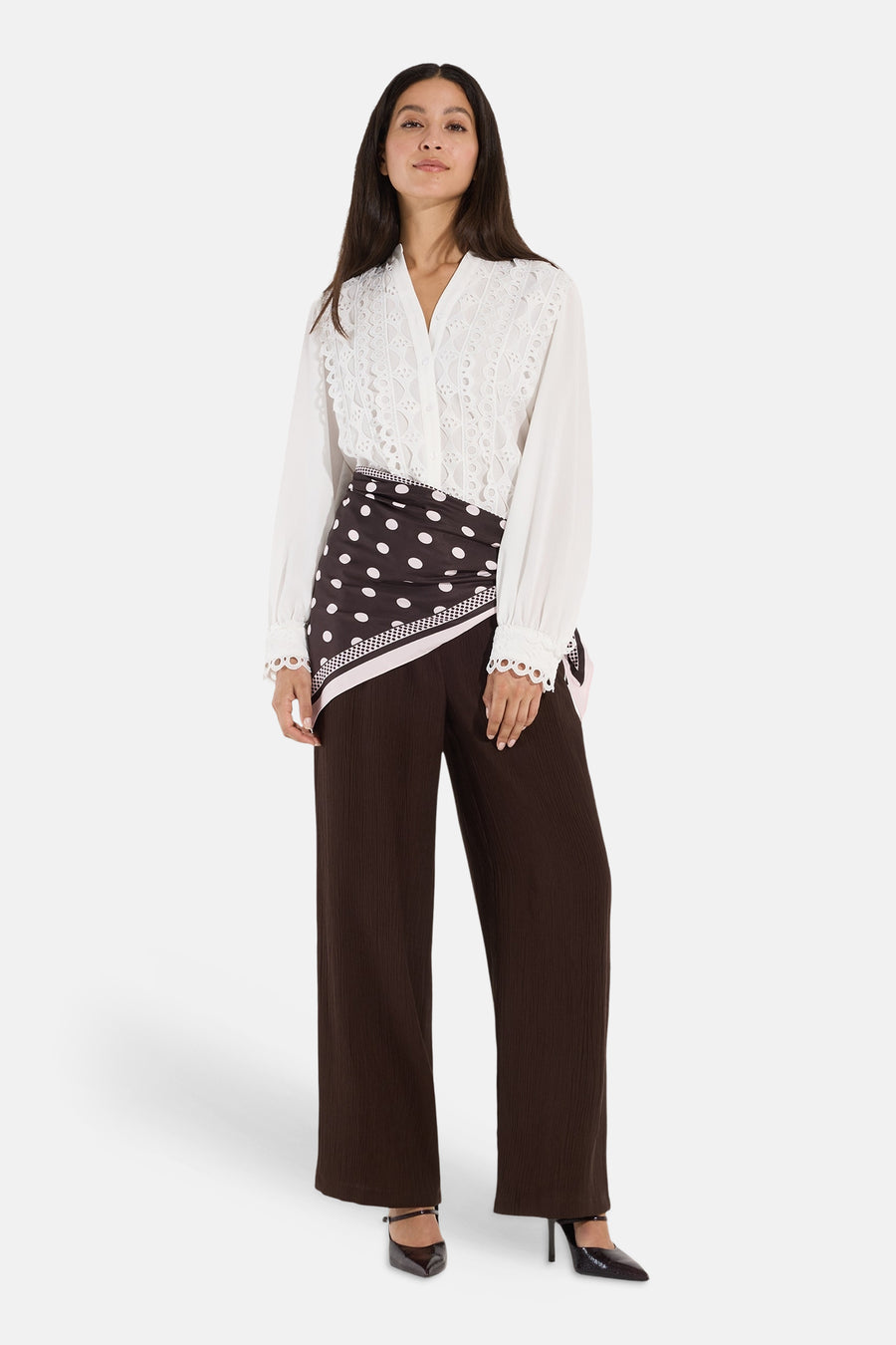 White long-sleeve blouse with lace detailing by MORE & MORE, worn with brown polka-dot wrap skirt and wide-leg trousers, full-length front view.