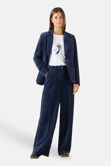 White short-sleeve t-shirt with illustrated graphic by MORE & MORE, worn under navy corduroy blazer and wide-leg pants, full-body lifestyle view