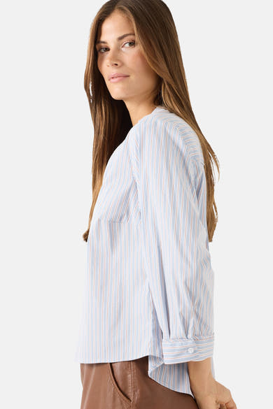 Multicolored long-sleeve striped blouse by MORE & MORE, side view with rolled cuffs and brown leather pants.
