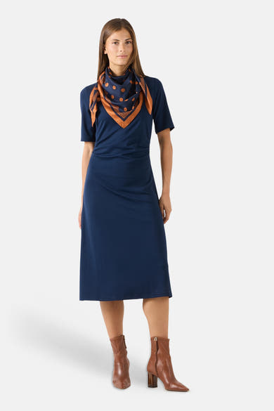 Multicolored silk foulard with navy base and orange polka dots by MORE & MORE, styled as a neck scarf with brown leather boots.