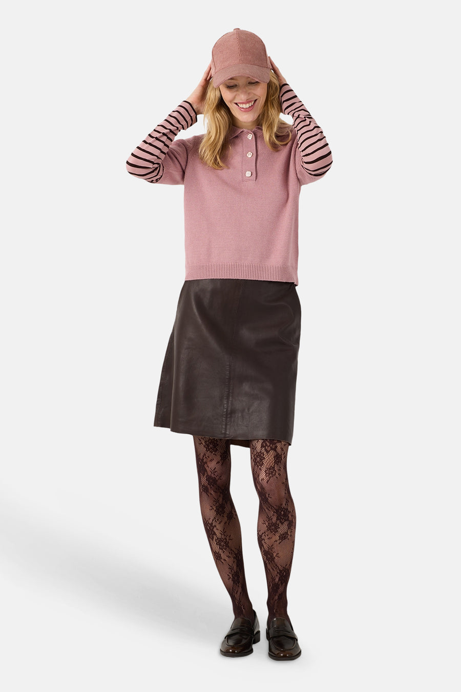 Pull rose à manches courtes MORE & MORE porté avec une jupe noire et un bonnet assorti.