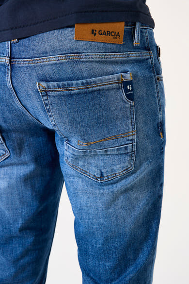 Jean tapered bleu denim, de GARCIA, avec poche arrière plaquée et étiquette en cuir à la ceinture.