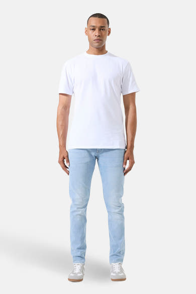 Jean droit en denim bleu clair de GARCIA, porté avec un t-shirt blanc et des baskets grises.