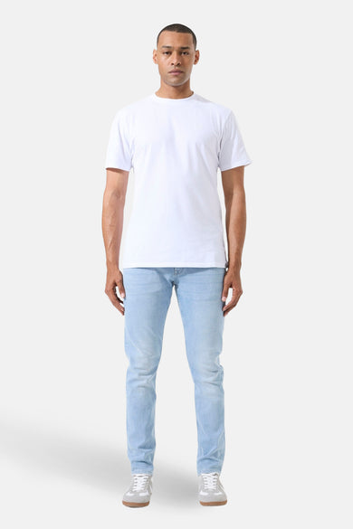 Jean droit en denim bleu clair de GARCIA, porté avec un t-shirt blanc et des baskets grises.