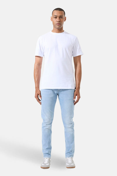 Jean droit en denim bleu clair de GARCIA, porté avec un t-shirt blanc et des baskets grises.