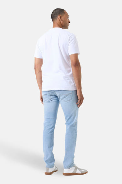 Jean droit en denim bleu clair de GARCIA, vue de dos, porté avec un t-shirt blanc et des baskets blanches.