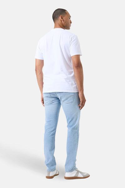 Jean droit en denim bleu clair de GARCIA, vue de dos, porté avec un t-shirt blanc et des baskets blanches.