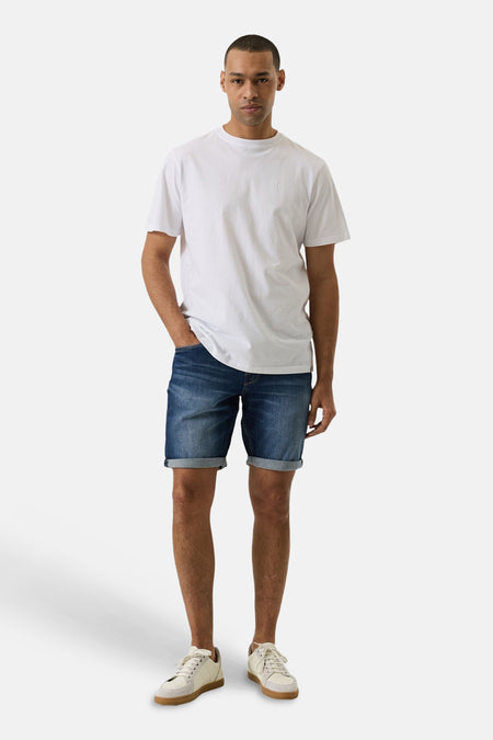 Short en jeans bleu moyen à revers de GARCIA, porté avec un t-shirt blanc et des baskets.