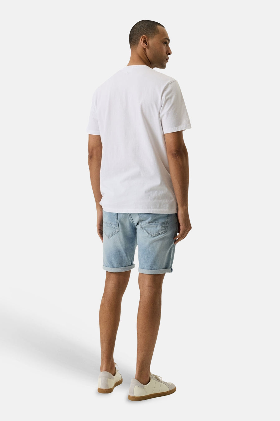 Short en jeans light blue denim de GARCIA, porté de dos avec un t-shirt blanc et des sneakers claires.