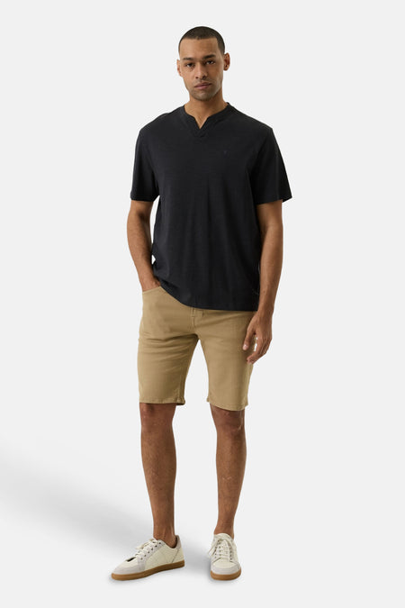 Short en jeans beige de GARCIA, porté par un homme avec un t-shirt foncé et des baskets claires.