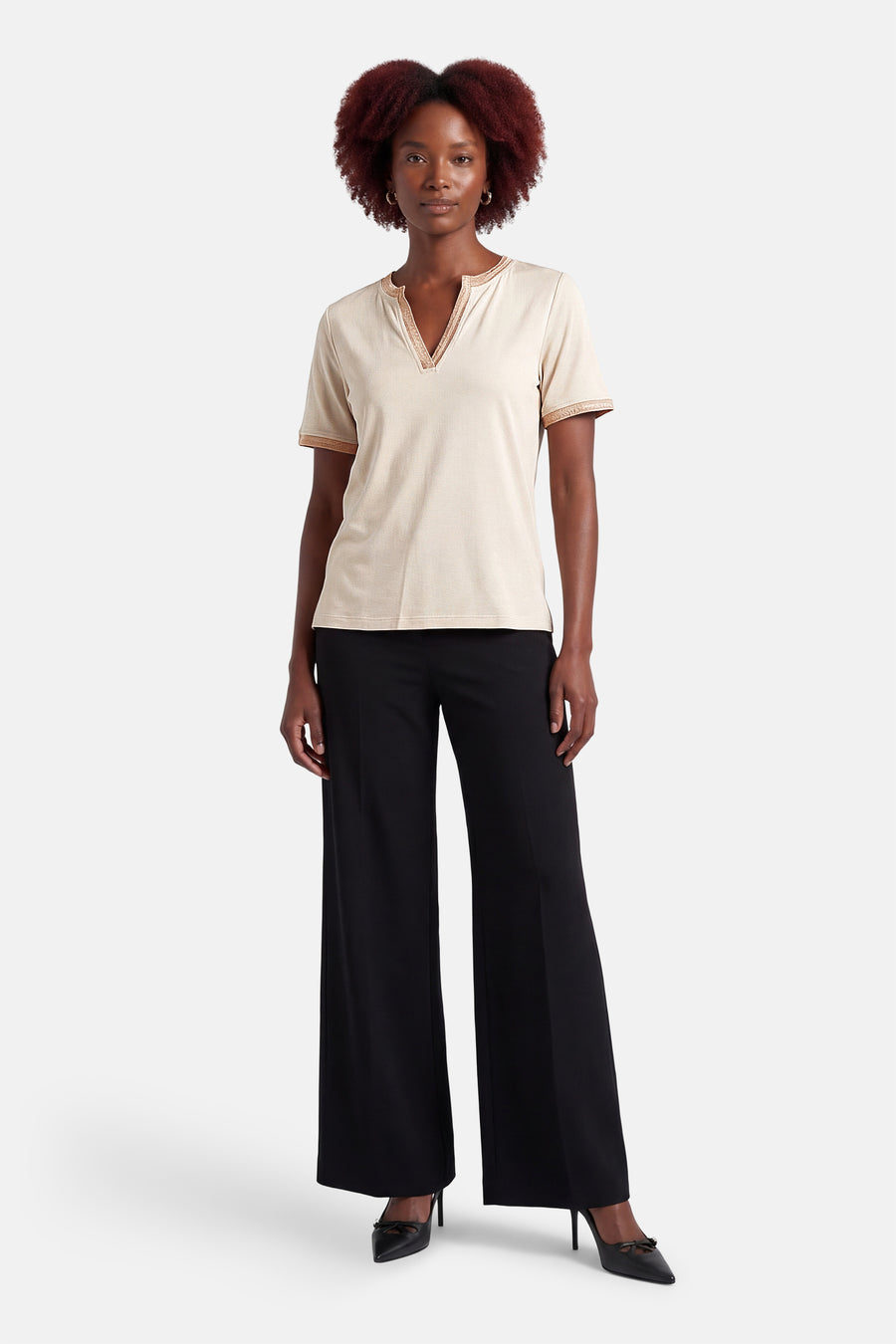 T-shirt à manches courtes beige de MORE & MORE avec garniture décorative, porté avec un pantalon noir et des talons hauts.

