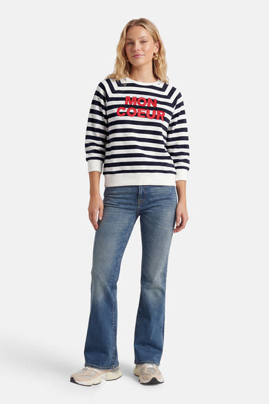 Sweat multicolore col rond de MORE & MORE, à rayures horizontales avec l'inscription "Mon Coeur" en rouge, porté avec un jean et des baskets.
