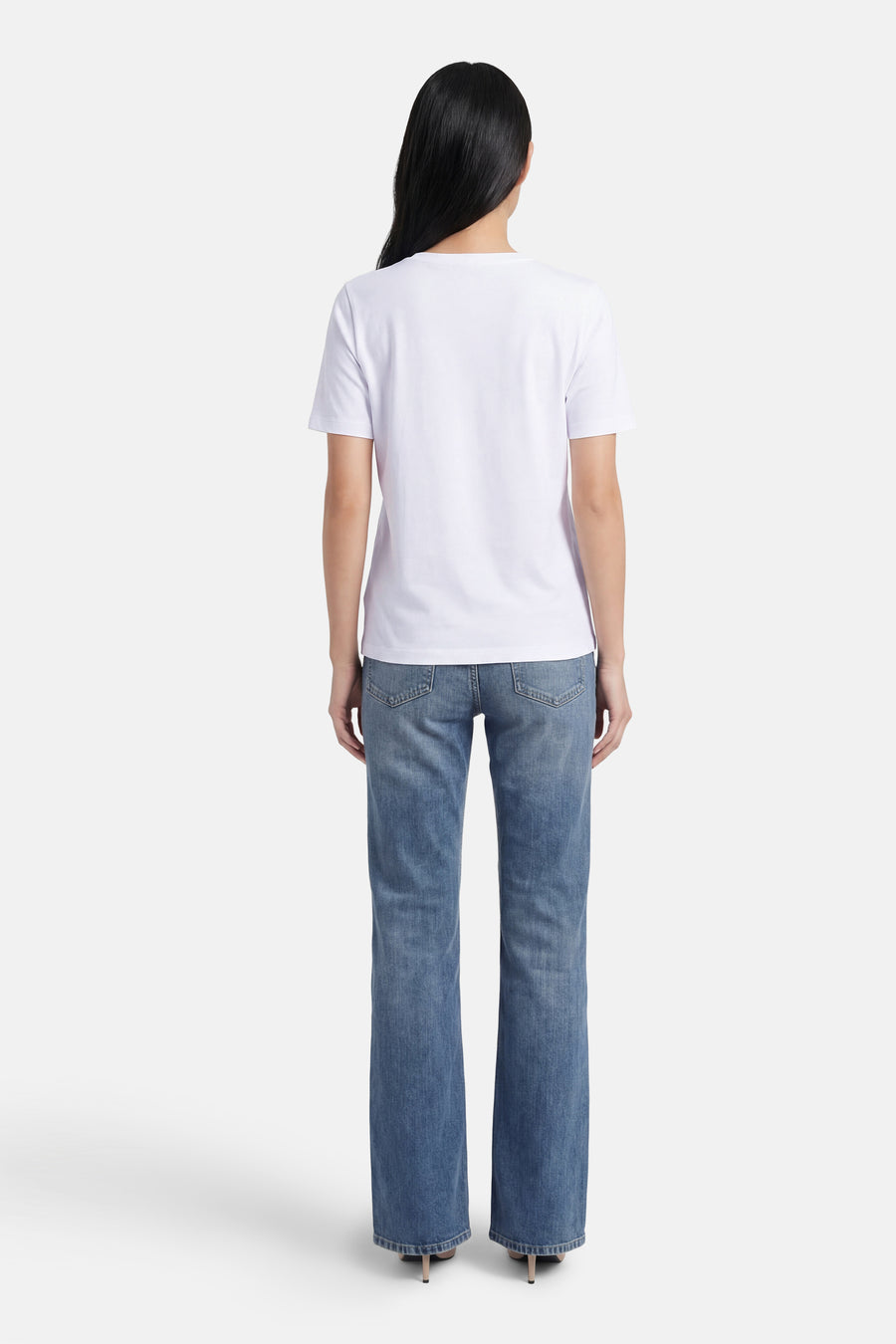T-shirt à manches courtes blanc de MORE & MORE, porté avec un jean bleu et des talons hauts.