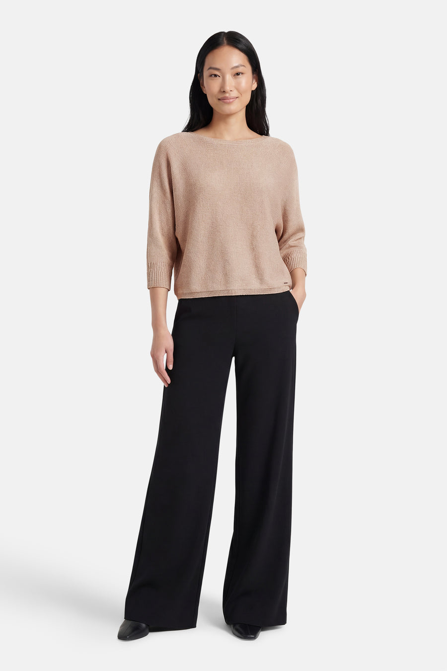 Pull beige à col rond de MORE & MORE, porté avec un pantalon noir ample.