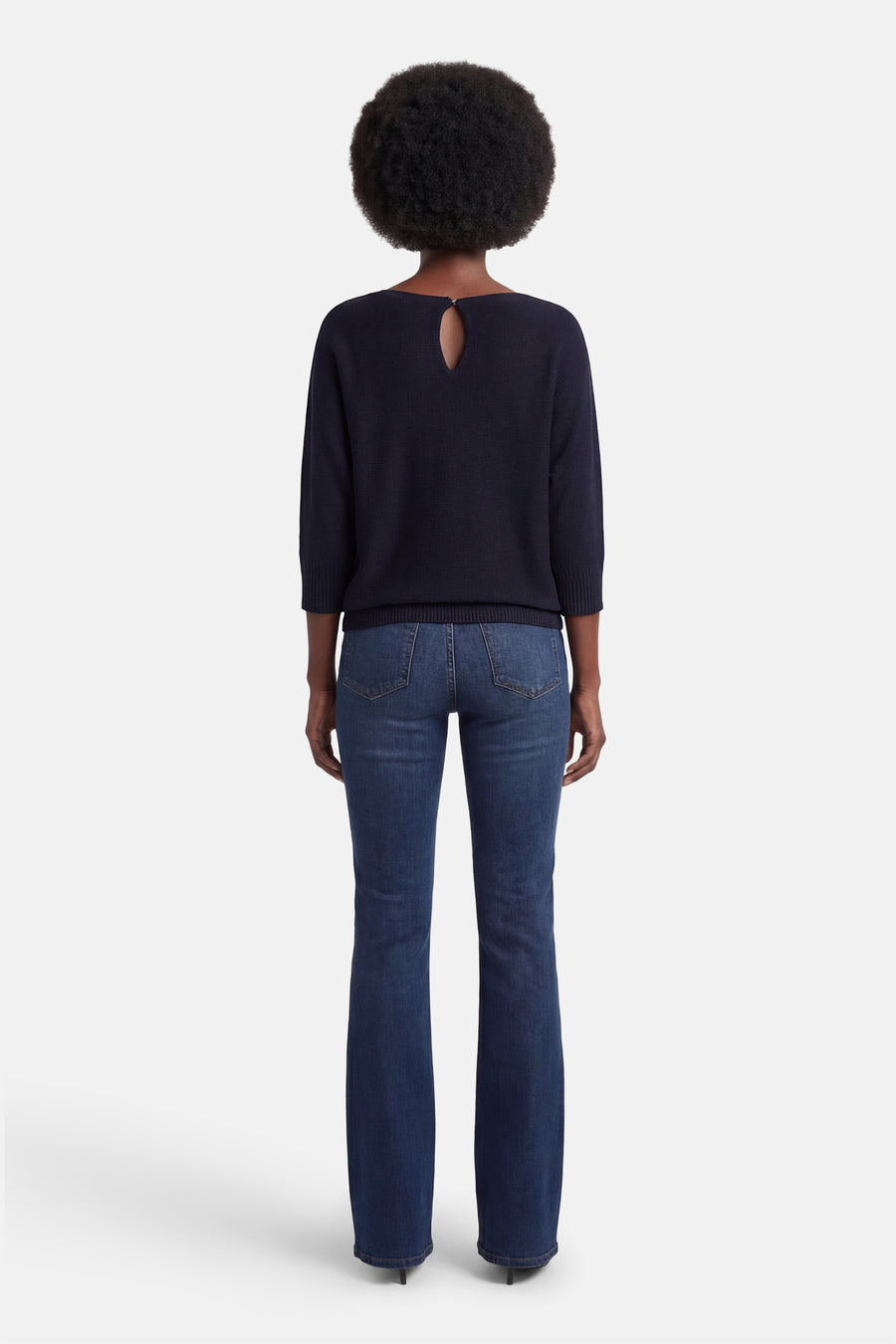 Pull à col rond bleu de MORE & MORE, avec découpe goutte d'eau au dos, porté avec un jean bleu.