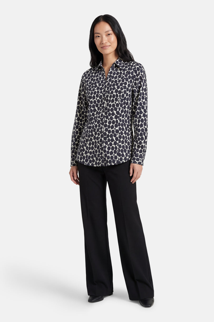 Chemise à manches longues bleue à pois, de MORE & MORE, portée avec un pantalon noir.