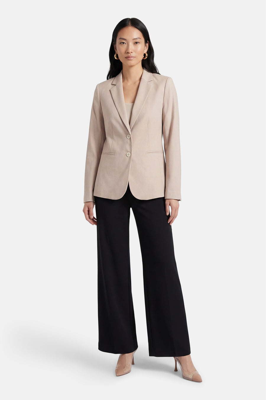 Beige blazer van MORE & MORE, met een sluiting met één knoop, gedragen met een zwarte broek en huidkleurige schoenen.
