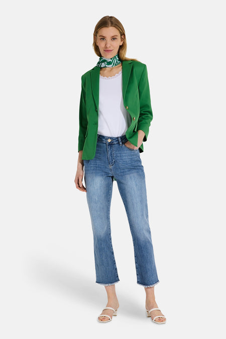 Jean cropped bleu clair de MORE & MORE, porté avec un blazer vert et un foulard à motifs.
