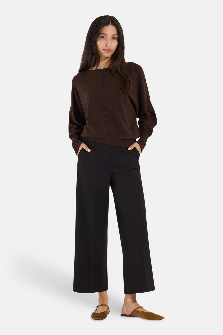 Brown round-neck sweater by MORE & MORE, featuring ribbed cuffs and hem, worn with black wide-leg pants and brown flats, front view.