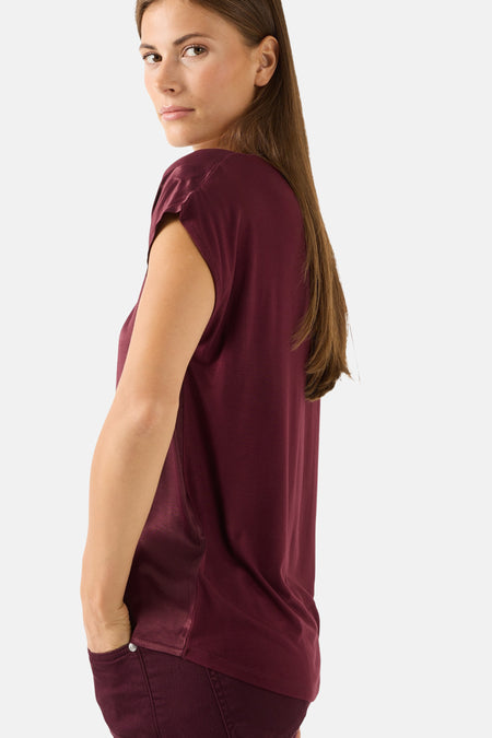 Burgundy short-sleeve chemisier by MORE & MORE, side view, smooth fabric, relaxed fit, model with hand in pocket