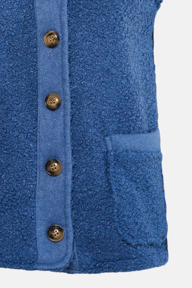 Gilet bleu en bouclette de Terra di Siena avec boutons marron et poche carrée.