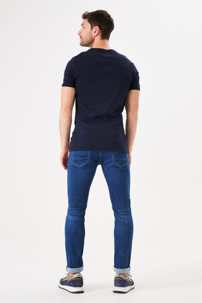 Blauwe spijkerbroek van GARCIA, gedragen met een marineblauw T-shirt en meerkleurige sneakers, achtergezicht.
