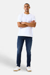 Jean slim en denim bleu foncé de GARCIA, porté par un homme avec un t-shirt blanc et des baskets blanches.