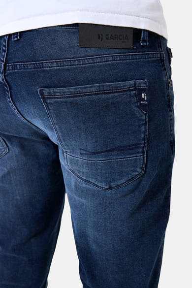 Jean slim en denim noir de GARCIA, vue de dos, avec étiquette en cuir et surpiqûres aux poches arrière.