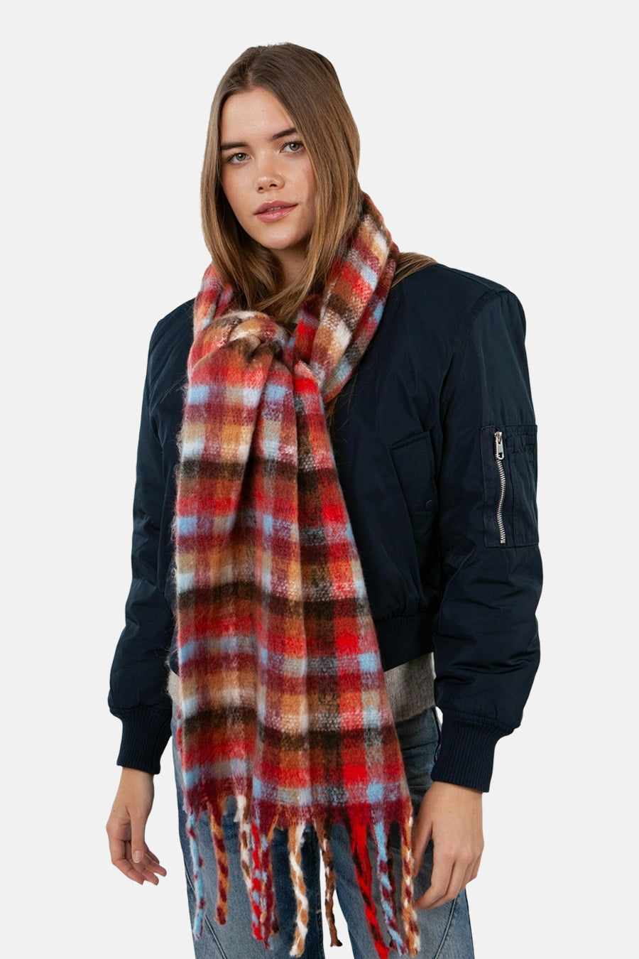 Écharpe multicolore de BARTS, à carreaux avec des franges, portée avec une veste bleu marine.

