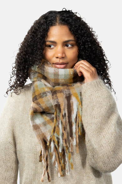 Multicolored plaid scarf with fringe by BARTS, worn around neck, featuring earthy tones and soft texture, paired with beige knit sweater, front view.