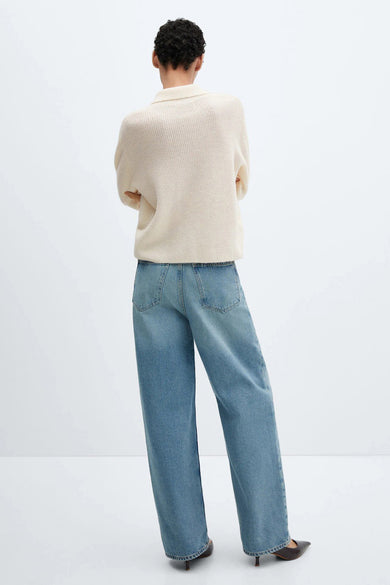 Pull beige de MANGO, porté avec un jean ample bleu et des escarpins pointus, vue de dos.
