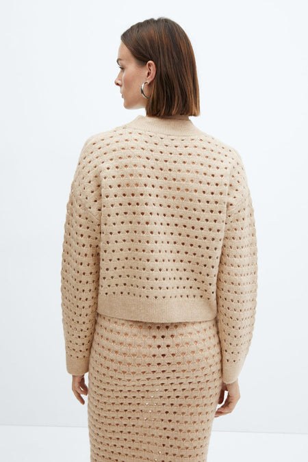 Pull beige ajouré de MANGO, porté avec une jupe assortie, vu de dos.