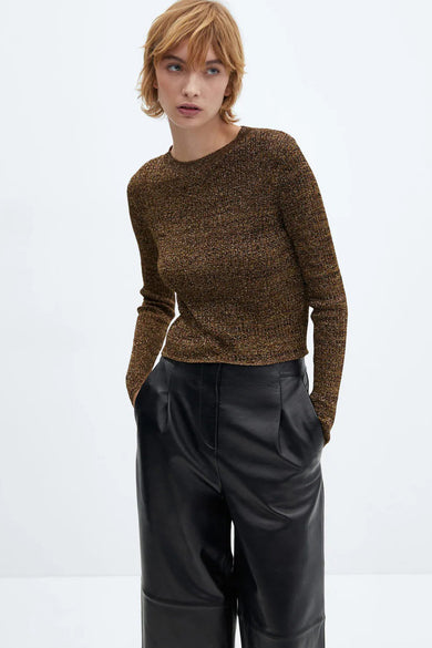 Pull brun col rond par MANGO, porté avec un pantalon large en cuir noir.
