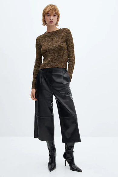 Pull col rond marron de MANGO, porté avec un pantalon large en similicuir noir et des bottes noires à talons aiguilles.