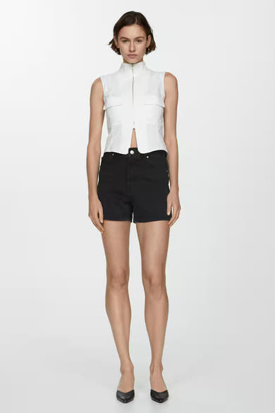 Zwarte MANGO short, gedragen met een witte top en zwarte pumps.