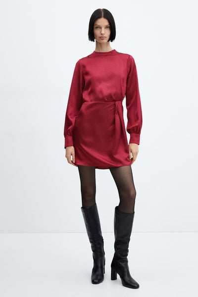 Robe midi rouge satinée de MANGO, avec manches longues, portée avec des collants noirs et des bottes en cuir.