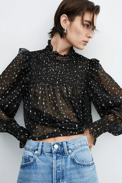 Blouse noire à manches longues de MANGO, imprimé à pois, avec fronces au niveau du col et des manches.