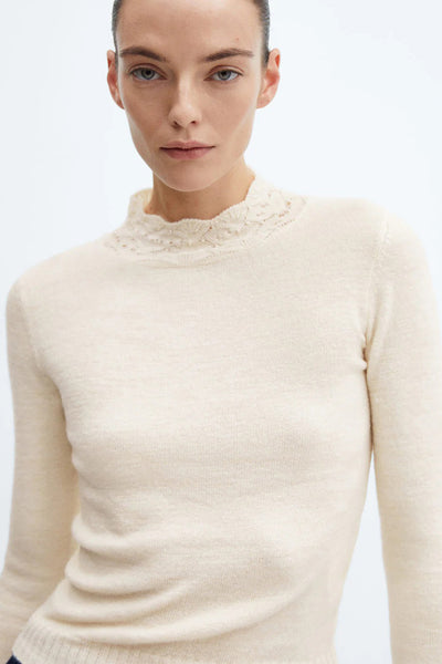 Pull beige de MANGO avec col montant orné de détails ajourés.