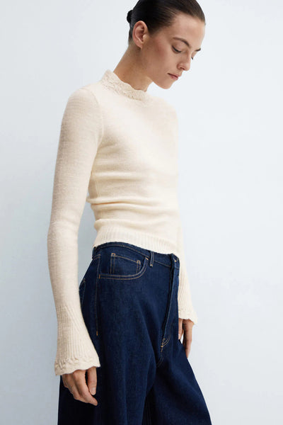 Pull beige col montant en maille fine de MANGO, avec bordure ajourée au col et poignets évasés.