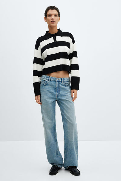 Pull noir à rayures par MANGO, porté avec un jean décontracté et des chaussures noires.