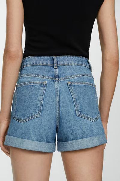 Short en denim bleu de MANGO avec ourlet retroussé, vu de dos.